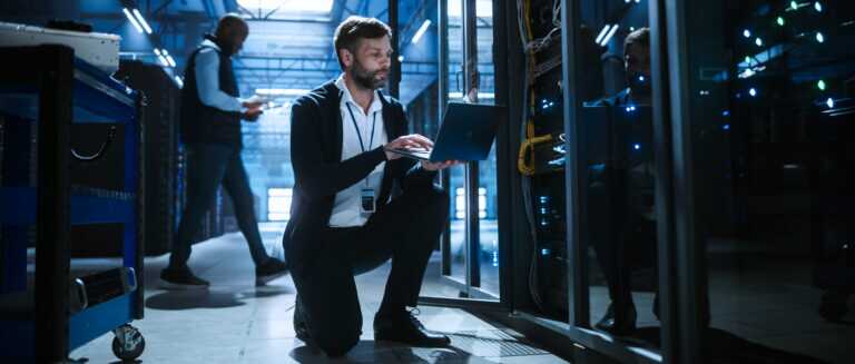 Technician Uses A Laptop Of Server Rack Systems In A Data Center