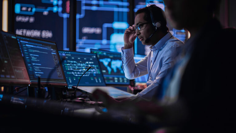 Man working in high security position overseeing computer displays.