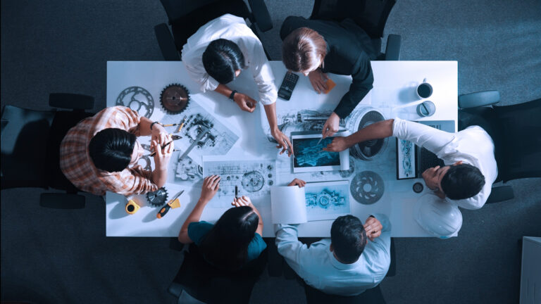 Top View Of Smart Team Working Together To Design Turbine Engine. Alimentation.