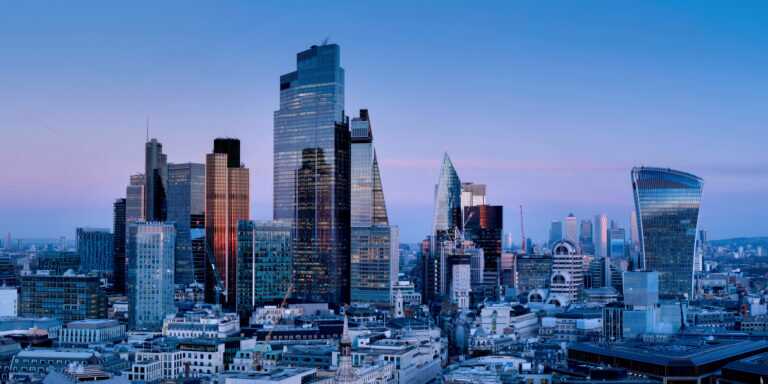 London skyline at dusk featuring prominent skyscrapers such as The Shard, 22 Bishopsgate, and the Walkie Talkie building.